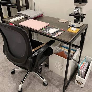 Reviewer image of gray rectangular desk with office supplies on it 