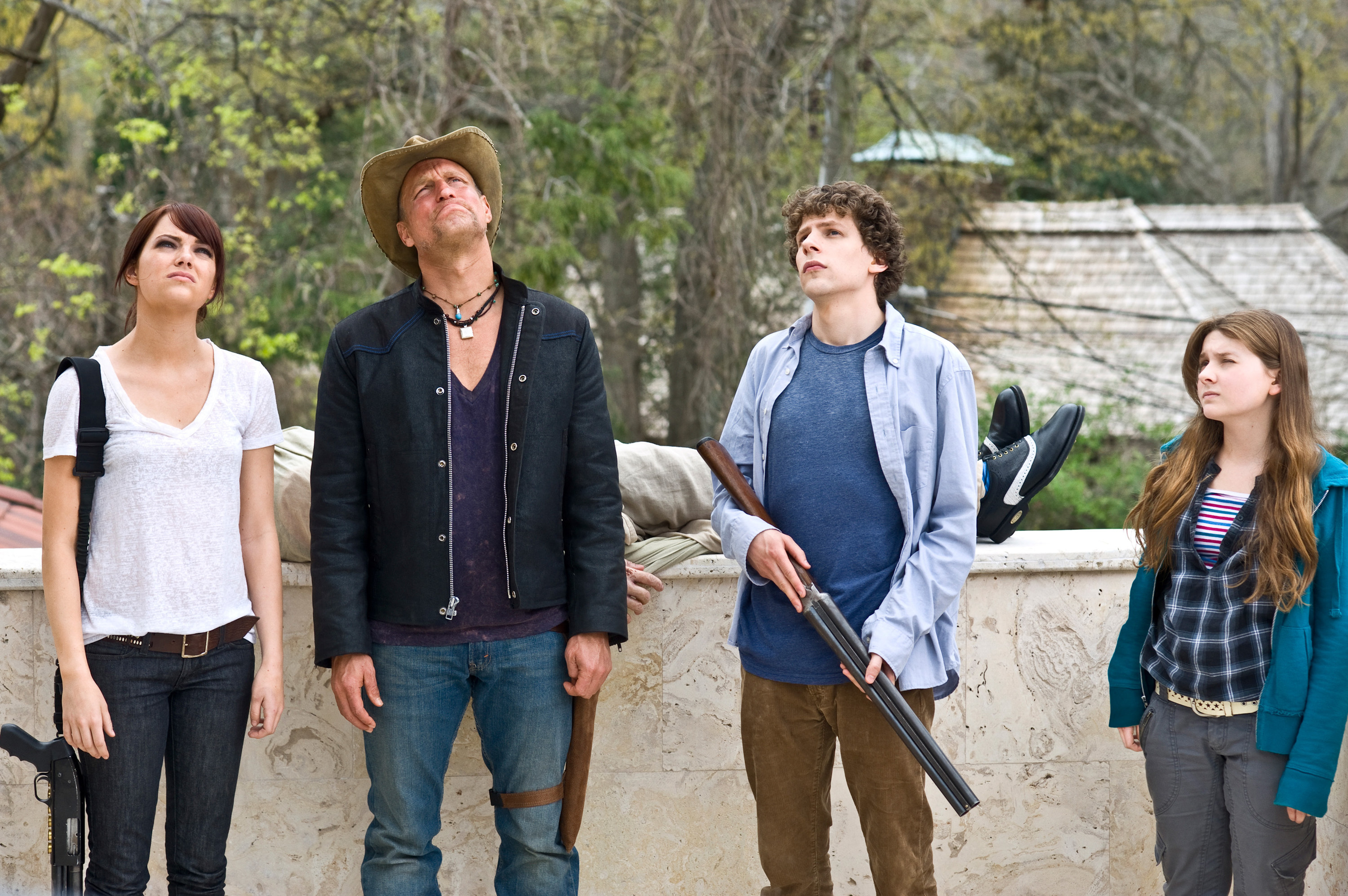 Emma Stone, Woody Harrelson, Jesse Eisenberg, and Abigail Breslin look into the sky with guns