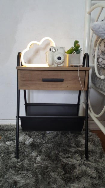 The wooden table with a metal frame, one drawer and a leather hammock underneath