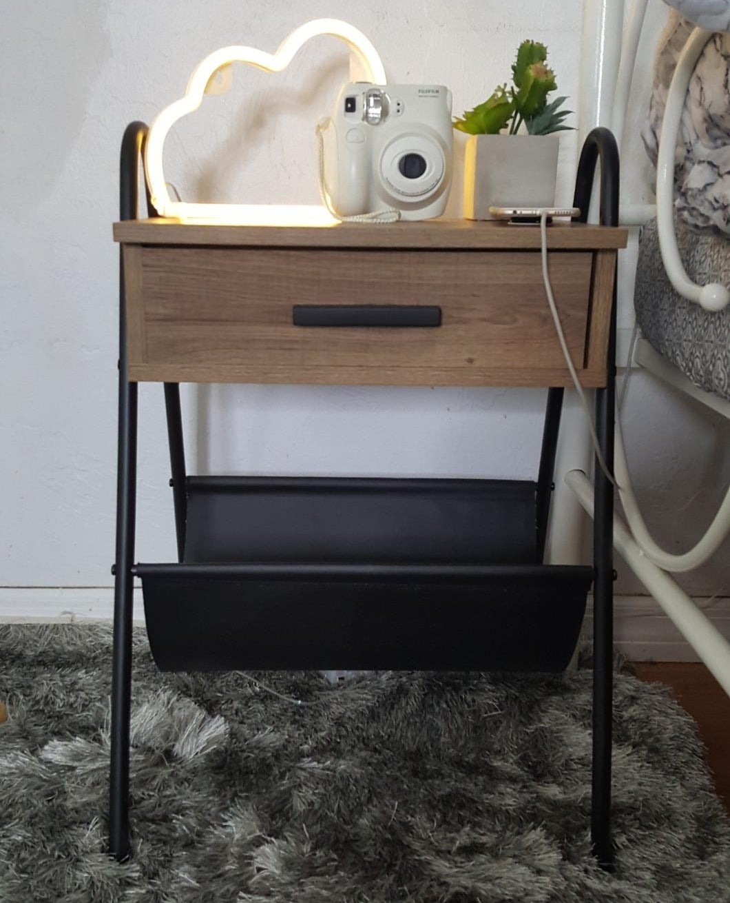 The wooden table with a metal frame, one drawer and a leather hammock underneath