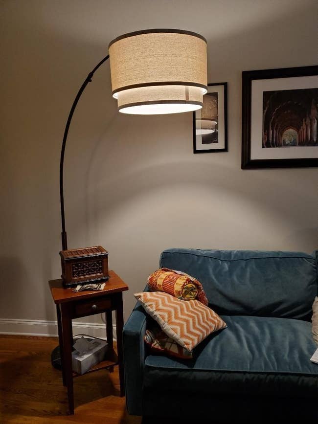 The floor lamp with a round base, big arch, and hanging drum lampshade