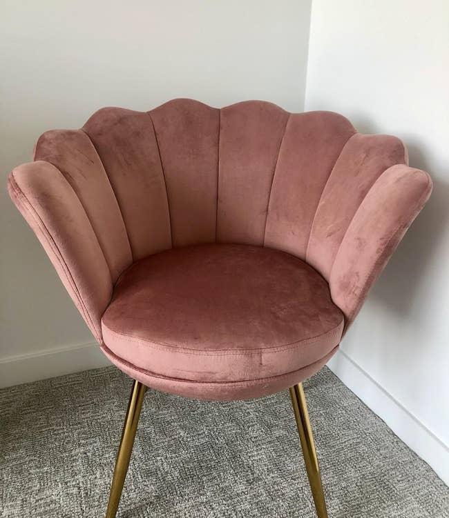 The petal chair in blush with a flower-shaped back and four gold legs