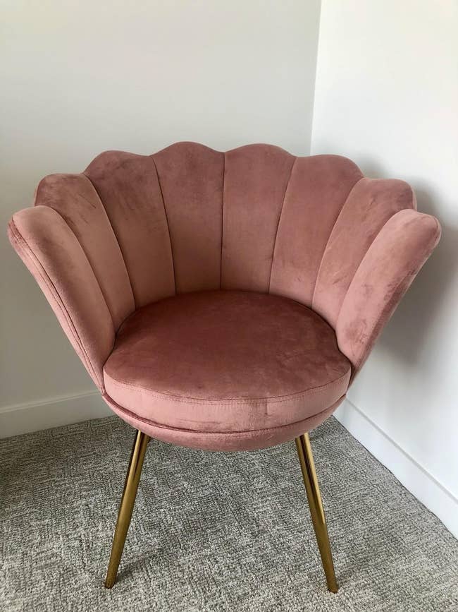 The petal chair in blush with a flower-shaped back and four gold legs