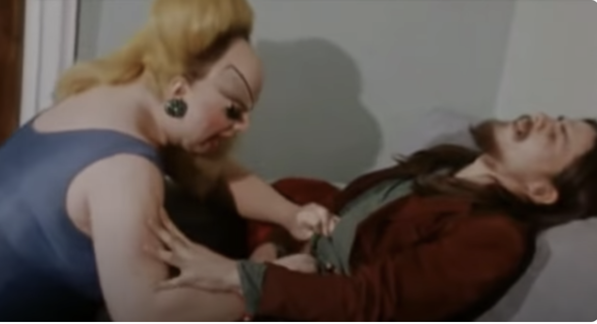 Divine pulling at the pants of her character&#x27;s son in the film