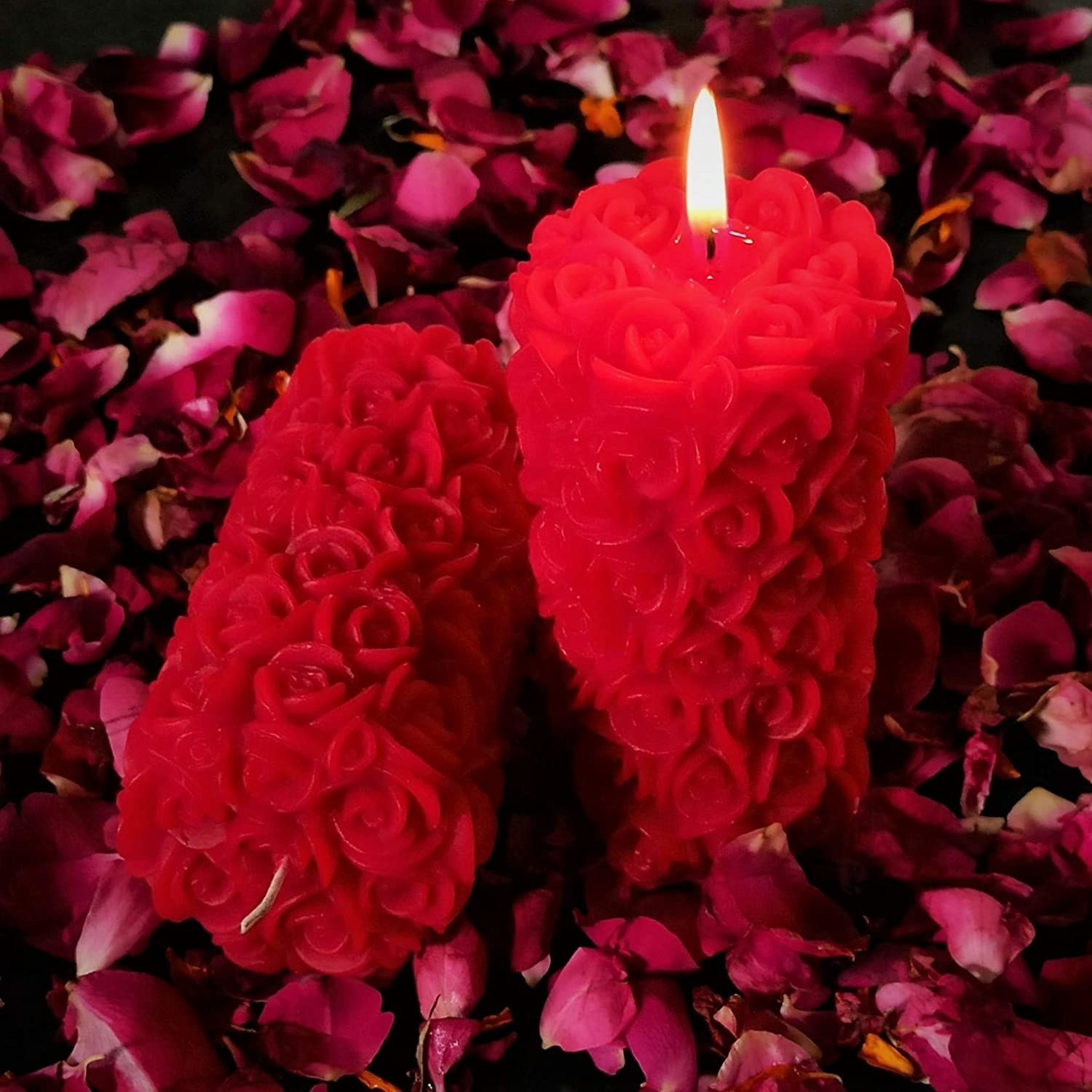 Bright red candles with little wax roses on their surface.
