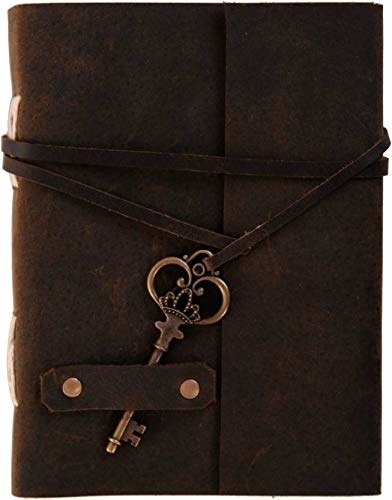 A leather journal with a binding strap and a decorative, vintage key charm.