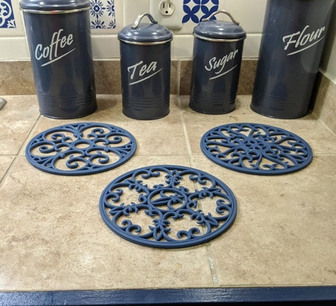 The trivets in dark blue on a reviewer&#x27;s countertop 