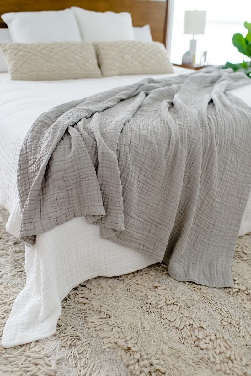 灰色的超大的棉布安慰毯子在床上有一个白色的被子”class=