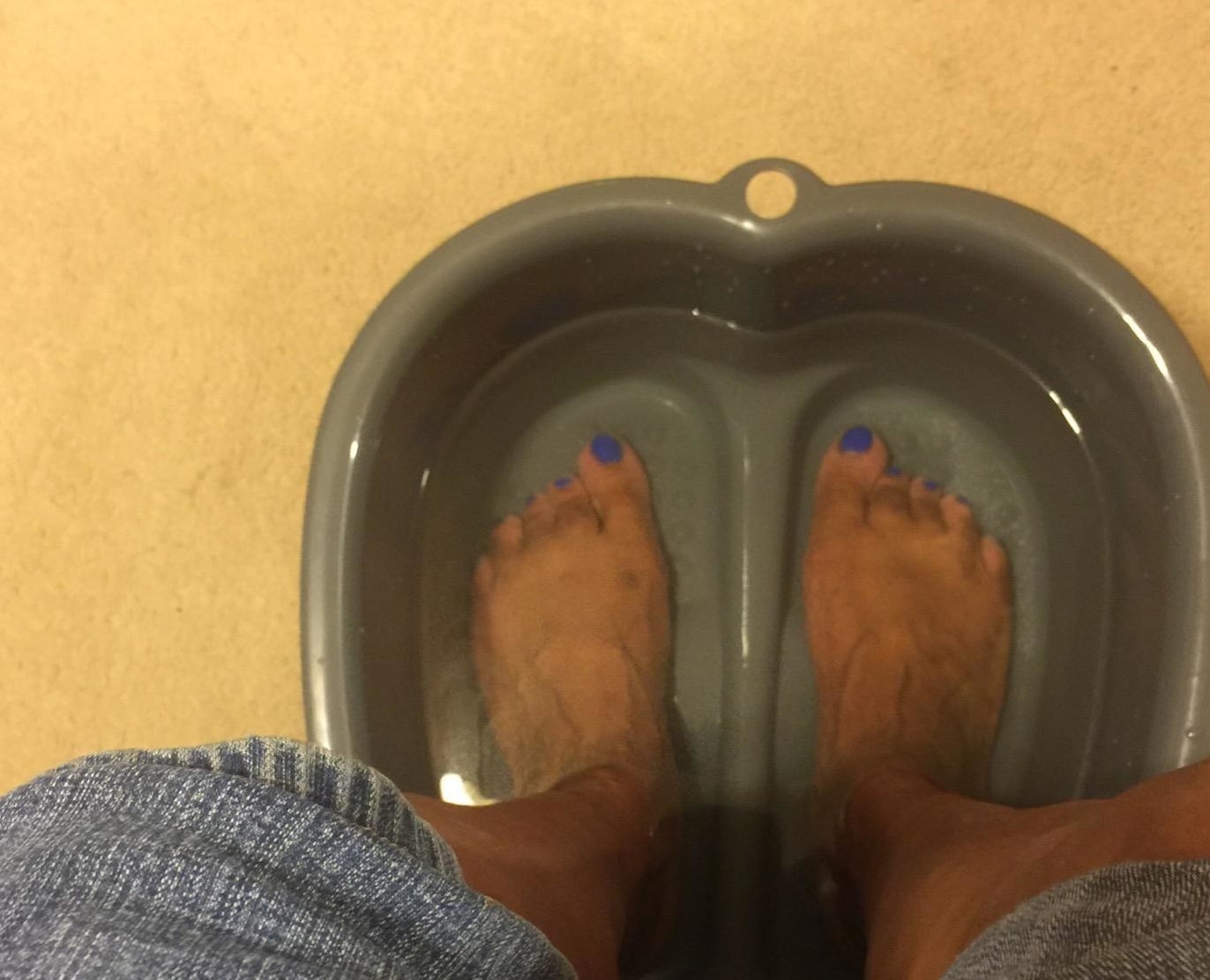 a reviewer photo of someone&#x27;s feet soaking in the basin 
