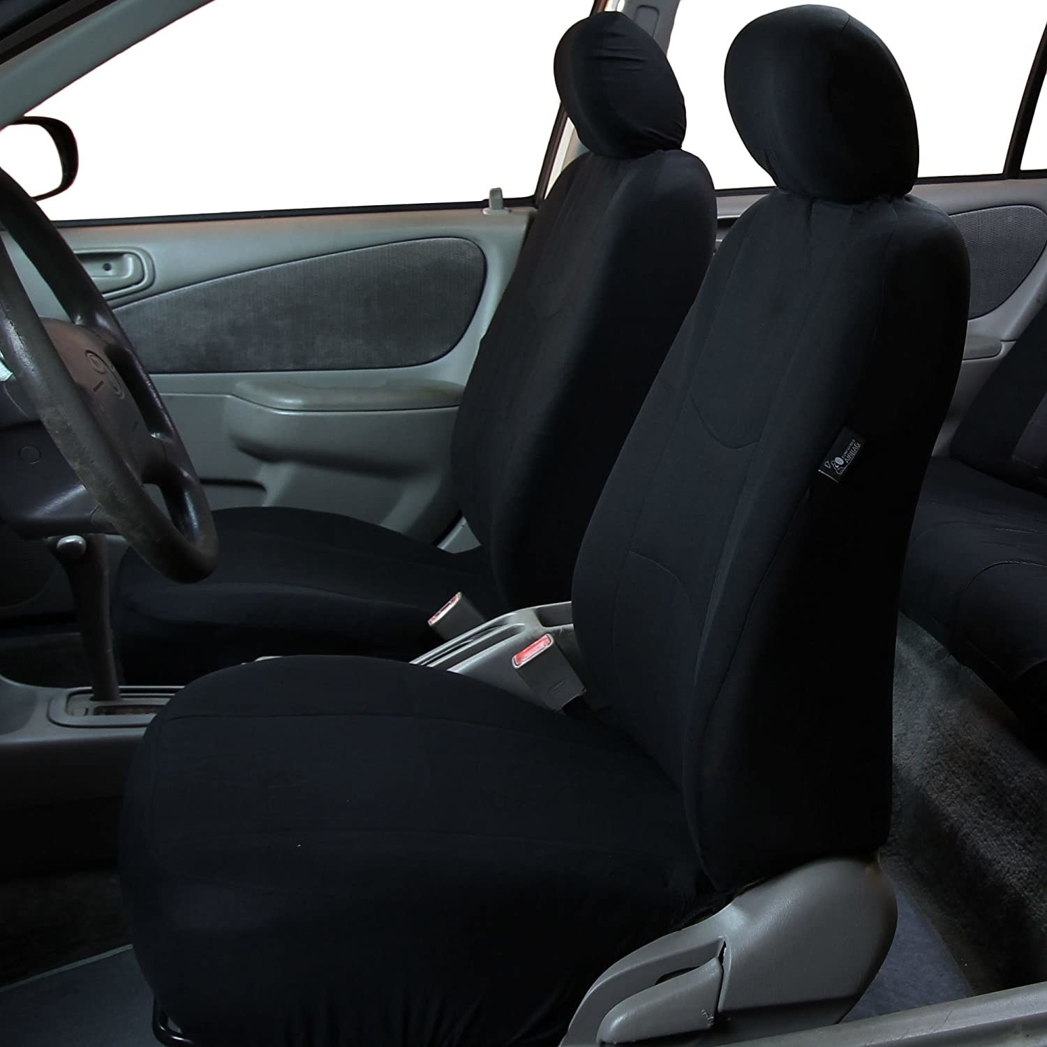 The front seats of a car with covers on them