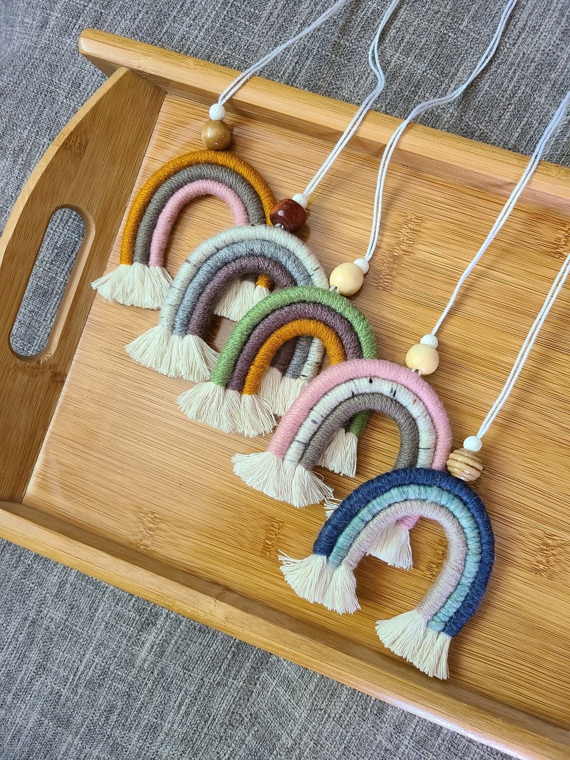 five rainbow macrame charms with a wooden bead on each 