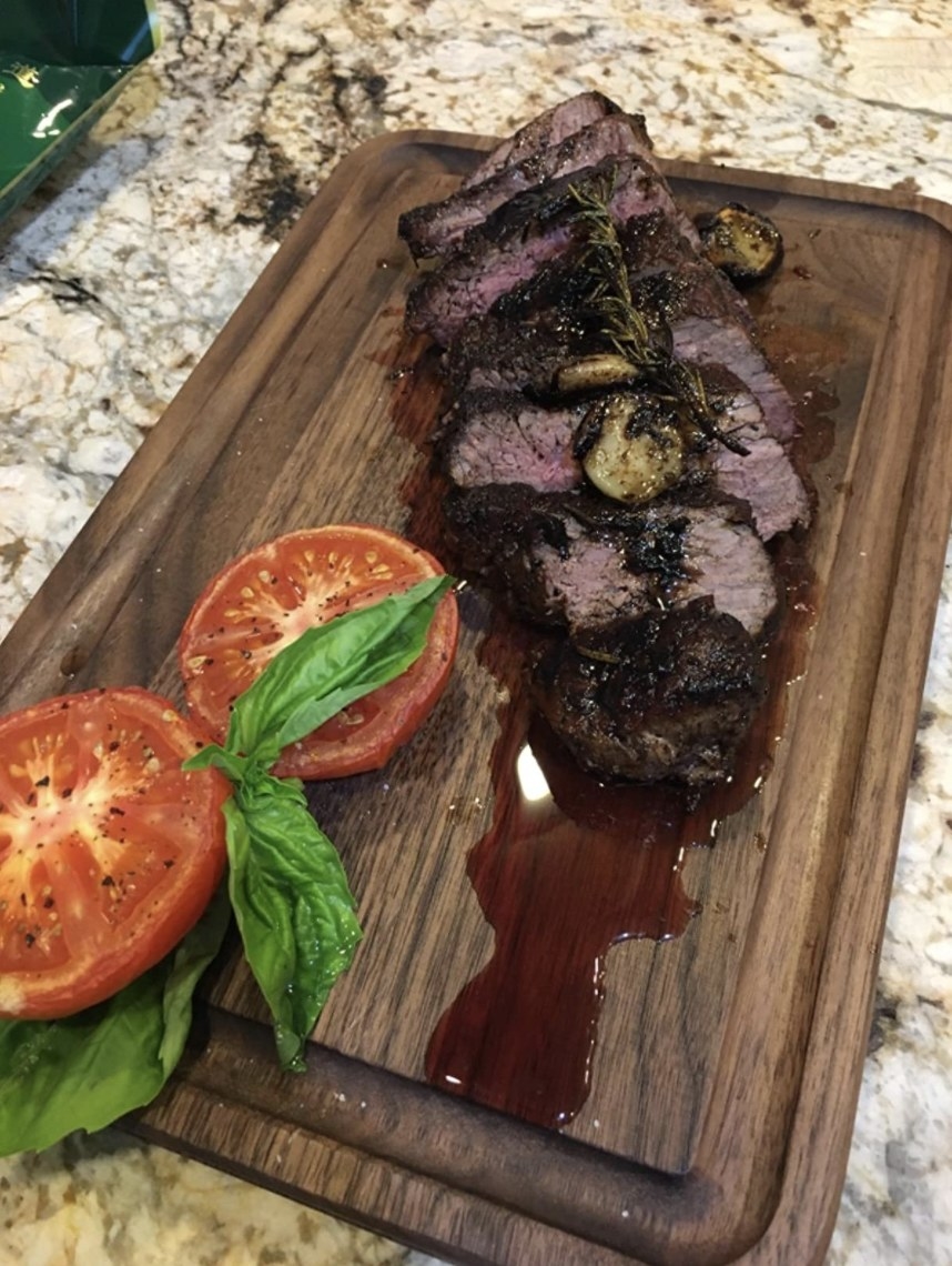 a wooden cutting board with a steak on it