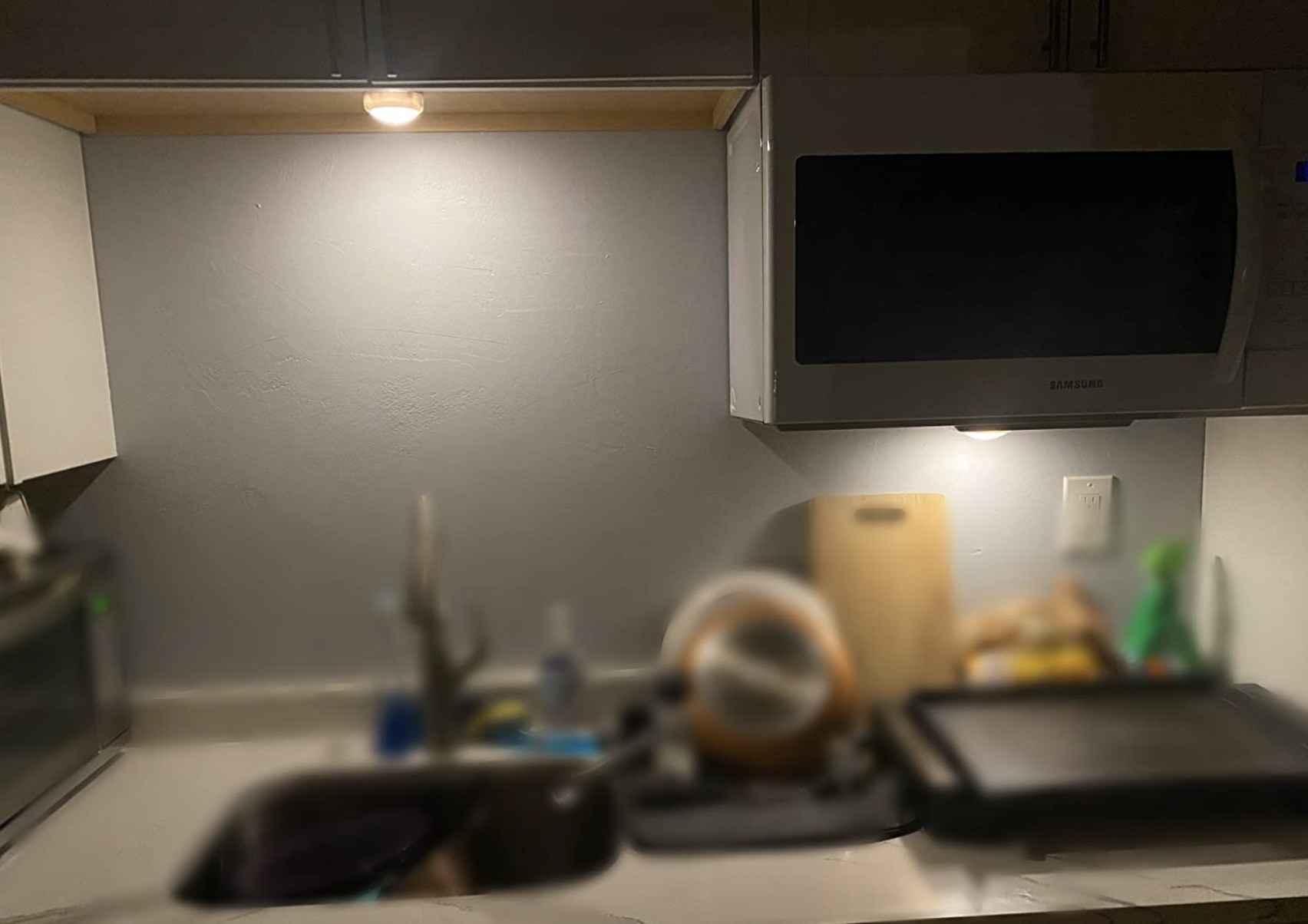 a puck light above a sink in a kitchen