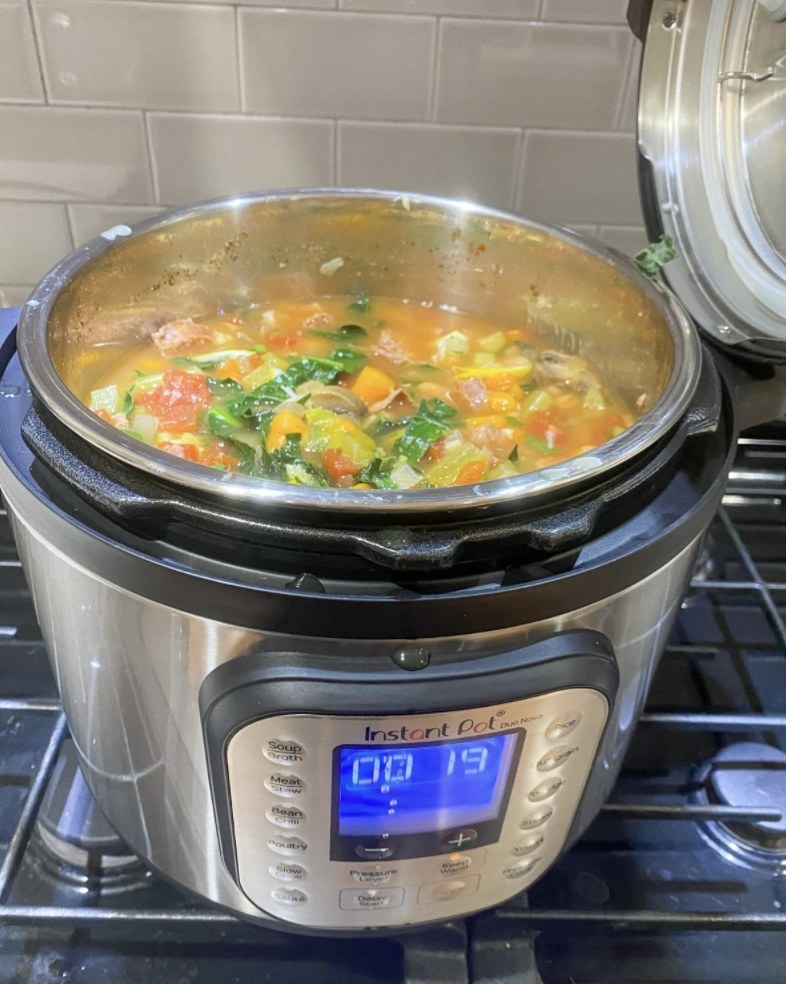 an instant pot on a stove with bean soup inside