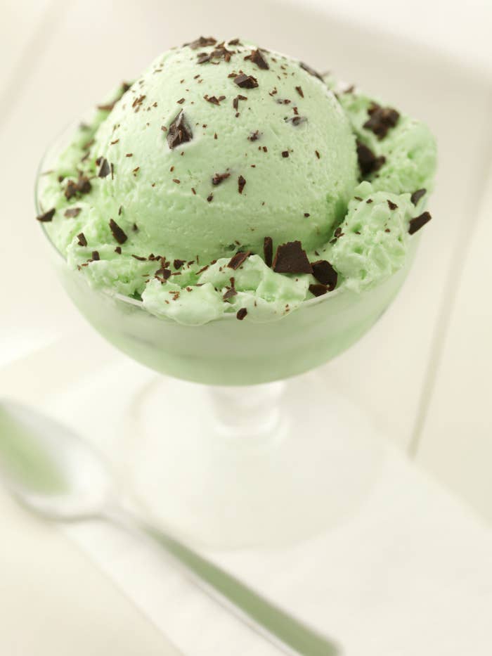 A tall bowl of mint chocolate chip ice cream.