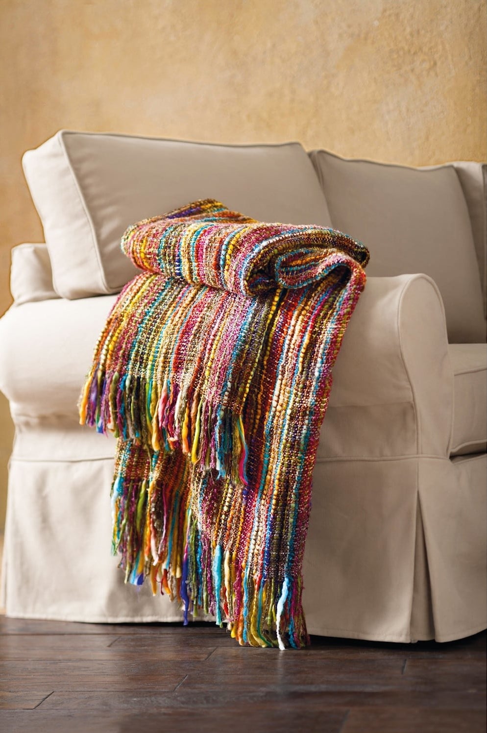 fringed rainbow throw on a couch