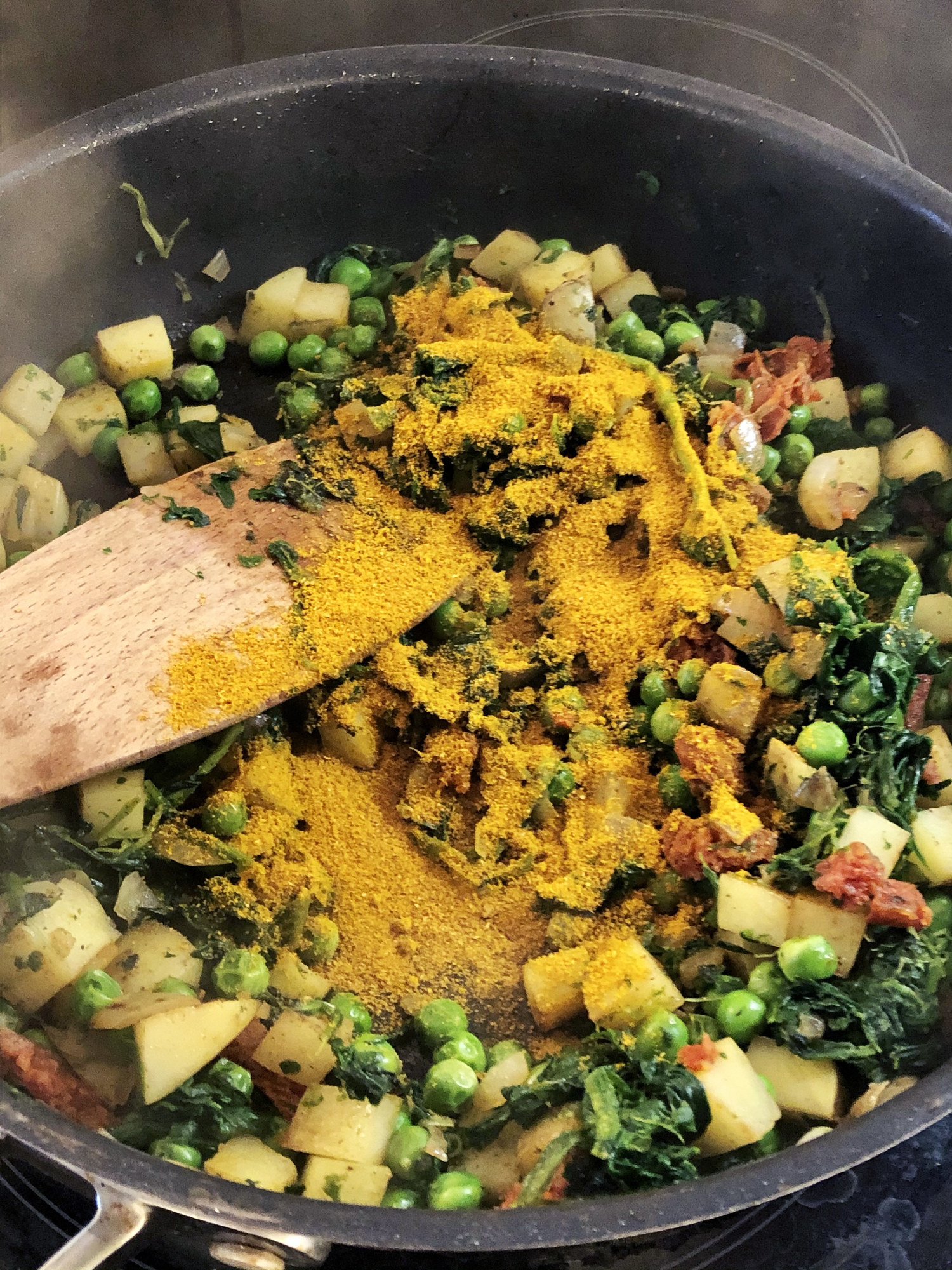 Garam masala on a bed of peas, kale, potatoes, and other vegetables
