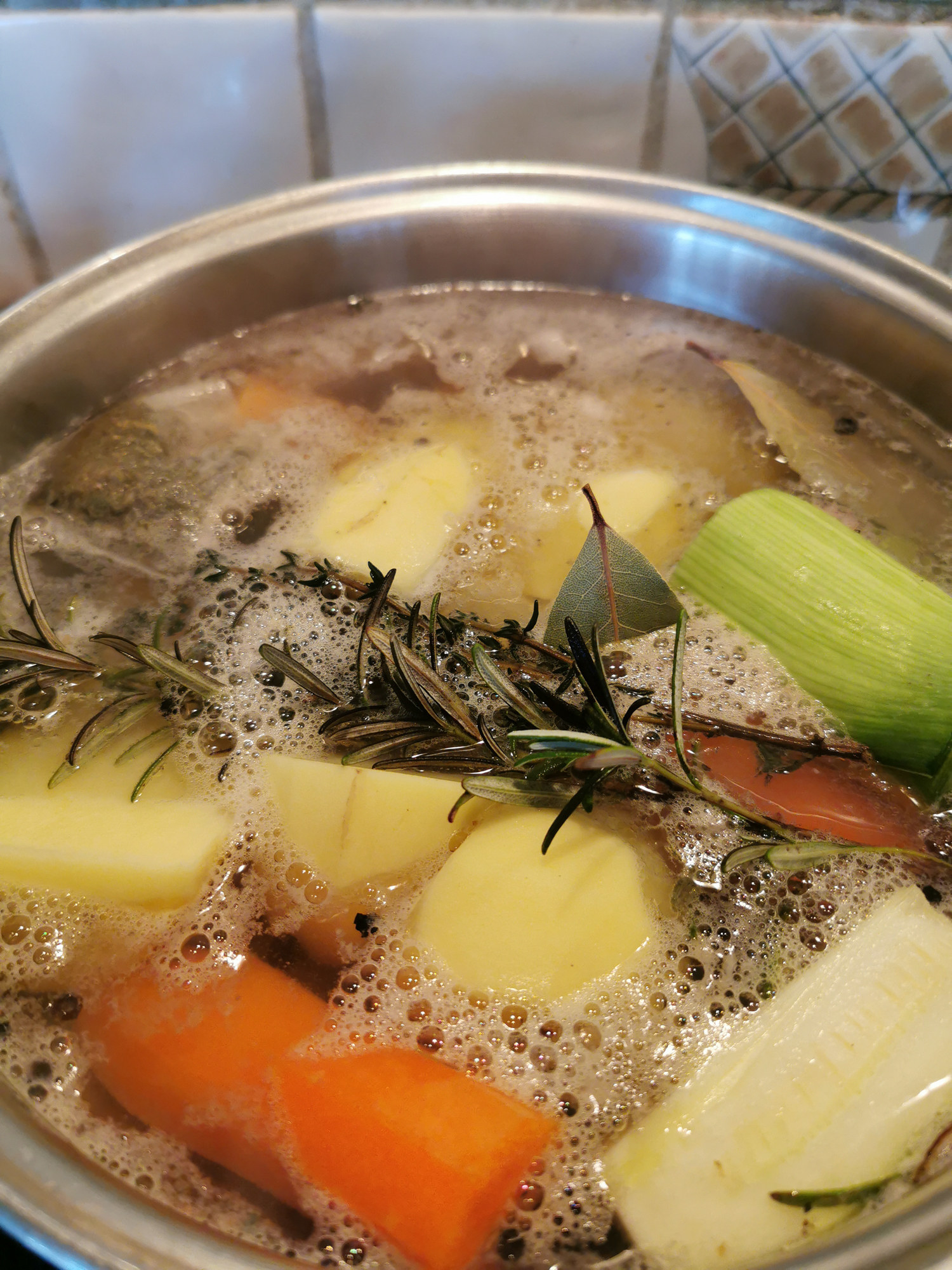 Making chicken soup with thyme and vegetables