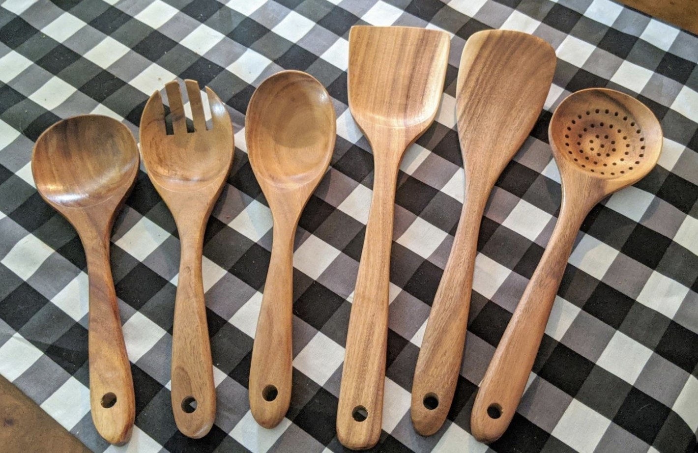 the full set of wooden kitchen utensils on a table