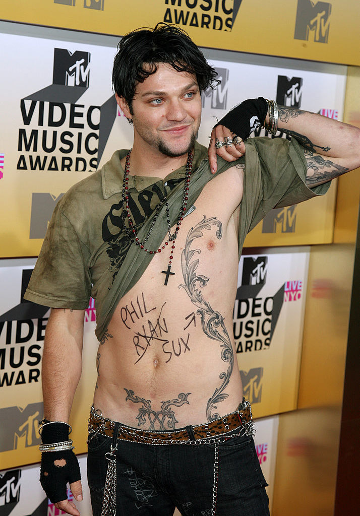 Bam lifting up his shirt as he poses on a the MTV VMAs red carpet