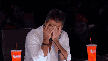 Simon Cowell covers his face in frustration 