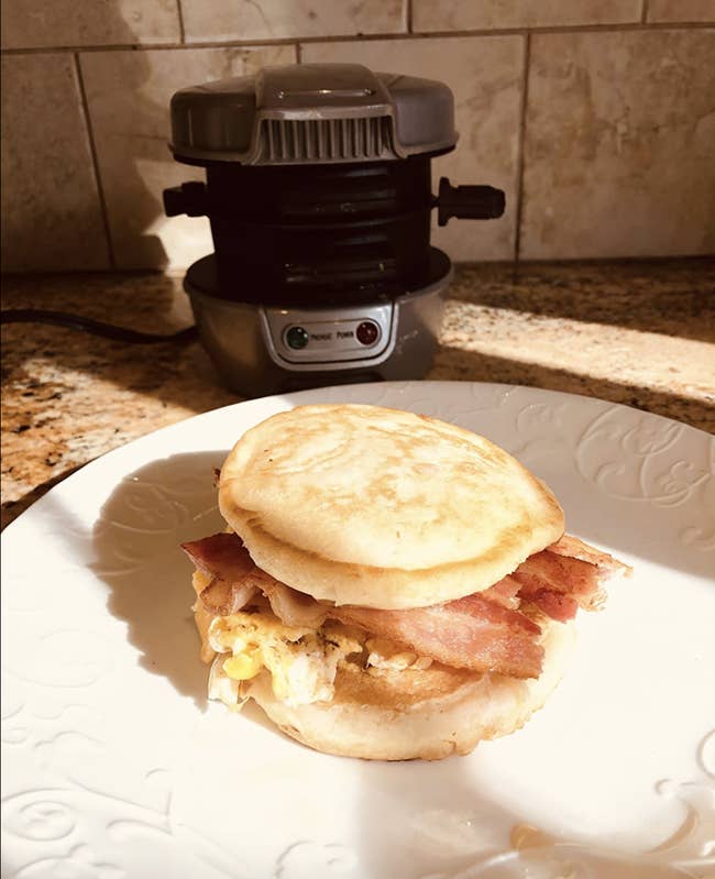 reviewer's egg bacon cheese sandwich sitting in front of the metal cylinder shaped cooker 