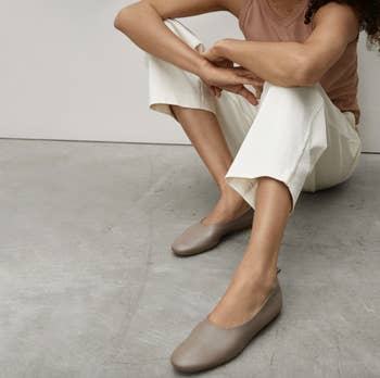 model wearing a pair of mocha leather flats