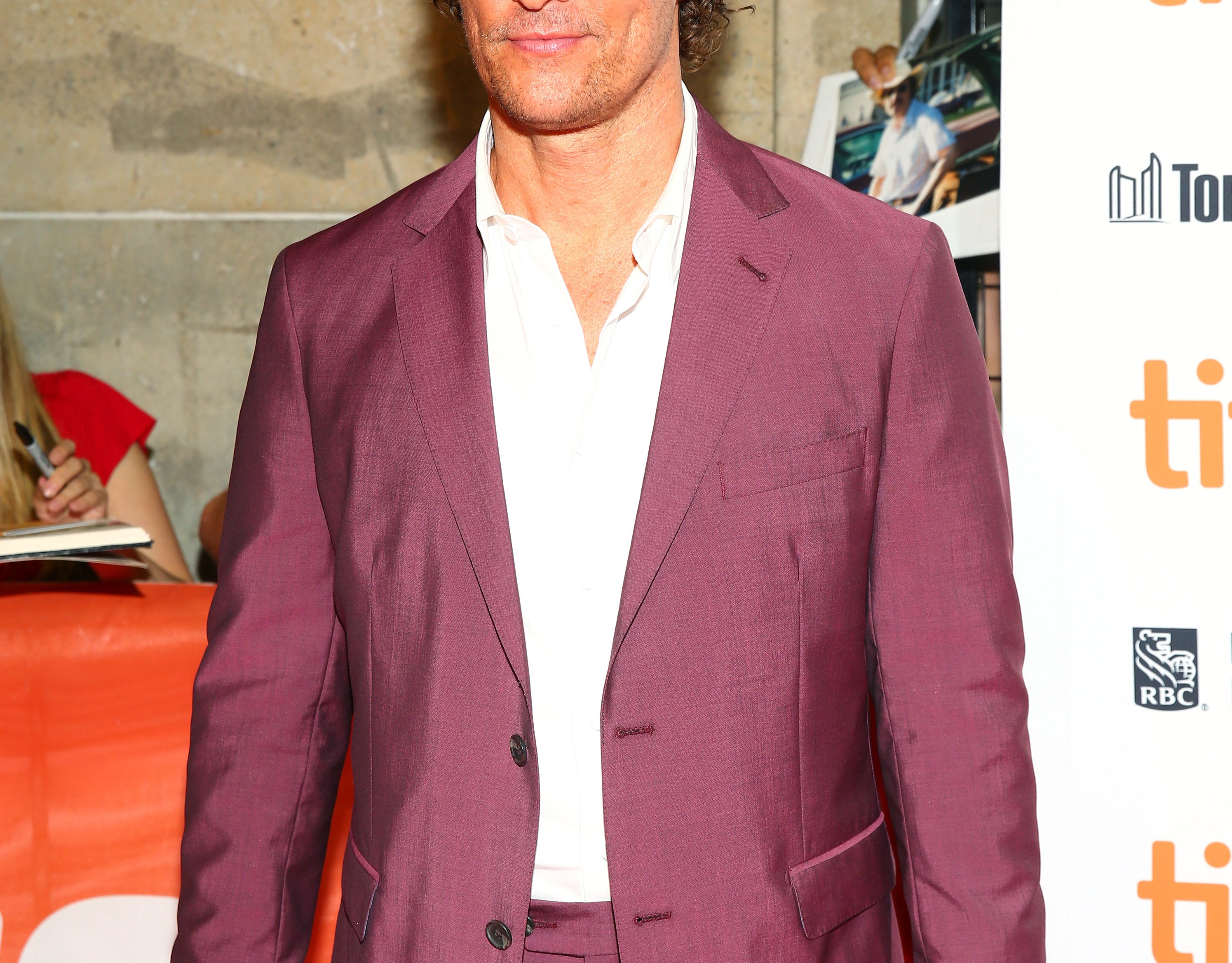 Matthew wears a maroon suit jacket to a film festival