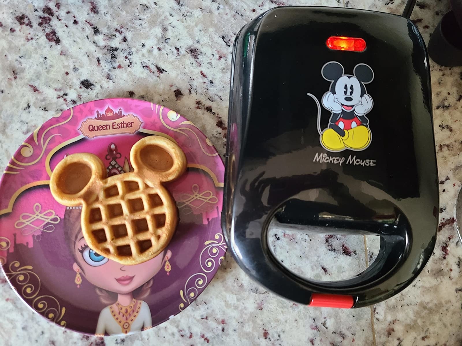 Plate with Mickey-shaped waffle next to waffle maker