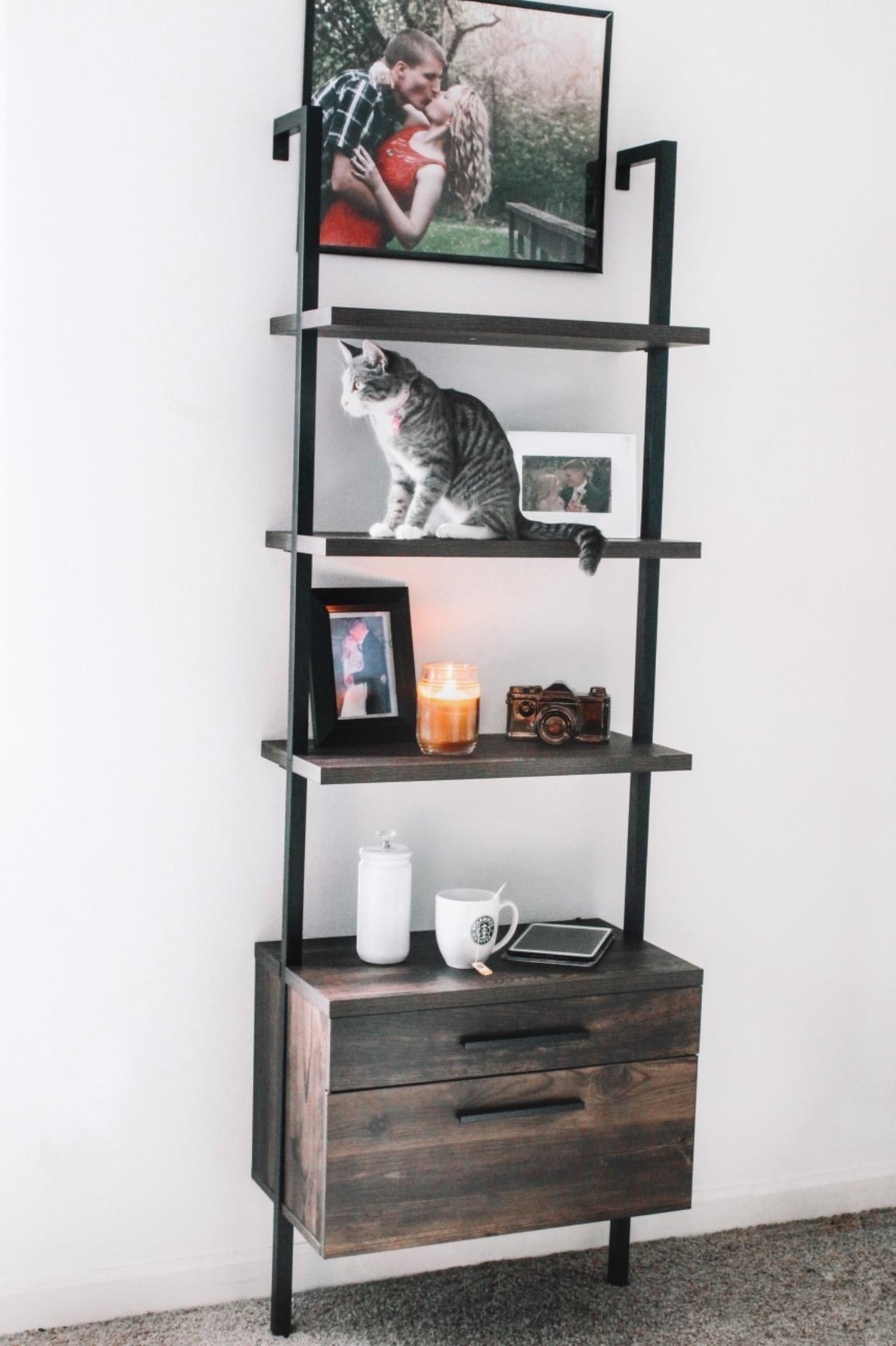 A reviewer photo of the bookcase in black metal and dark brown wood