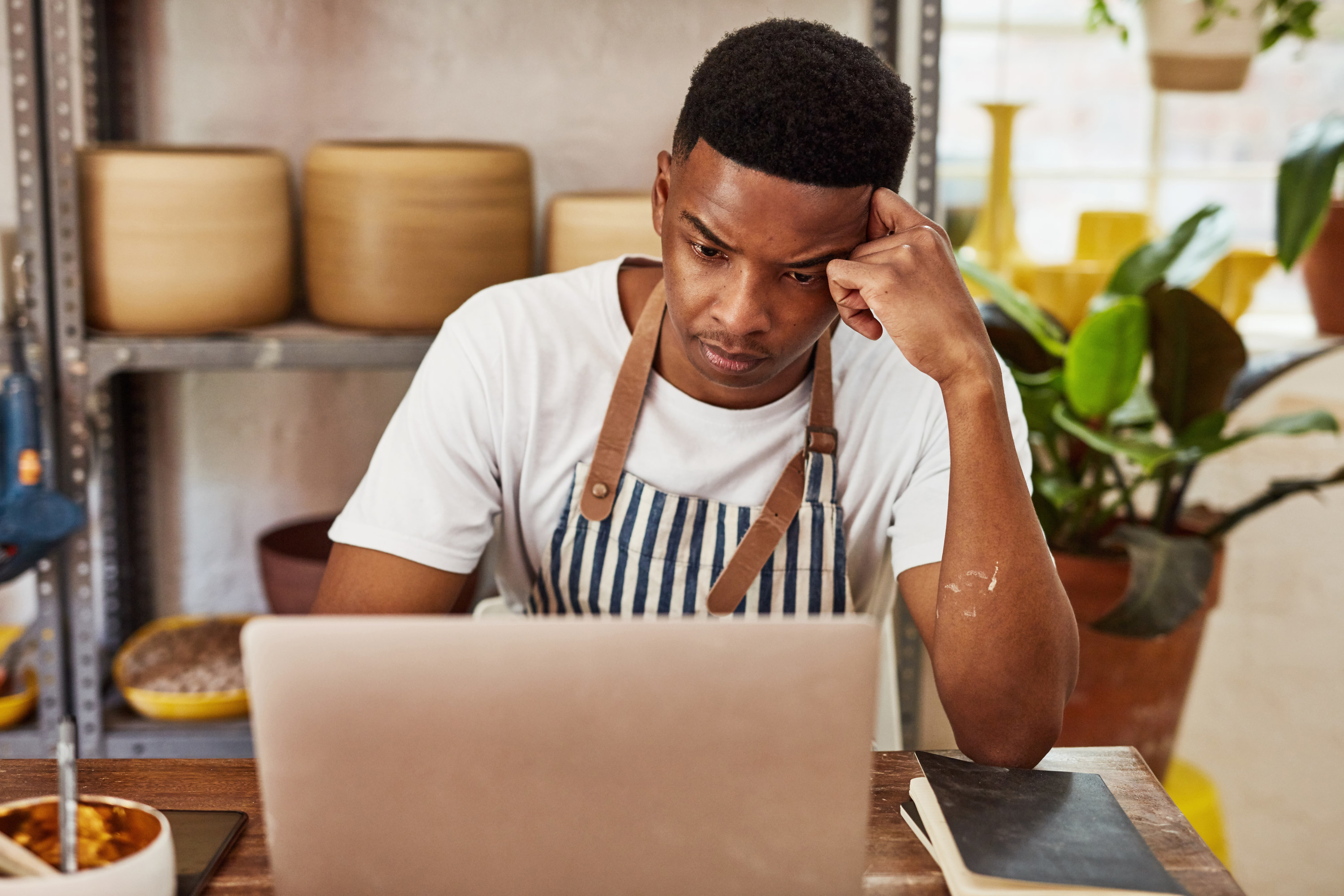 Small business owner working on a laptop in his studio