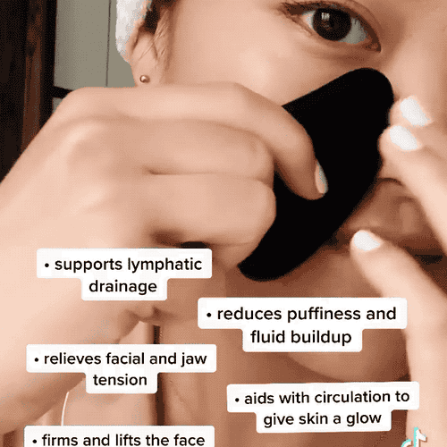 A GIF of someone using the obsidian gua sha on their cheek and jaw with the benefits listed, like helping circulation, relieving tension, firming and lifting the face, and reducing fluid buildup and puffiness