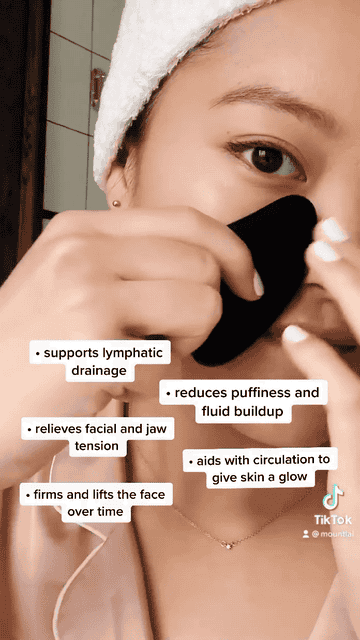 A gif of someone using the obsidian gua sha on their cheek and jaw with the benefits listed, like helping circulation, relieving tension, firming and lifting the face, and reducing fluid buildup and puffiness