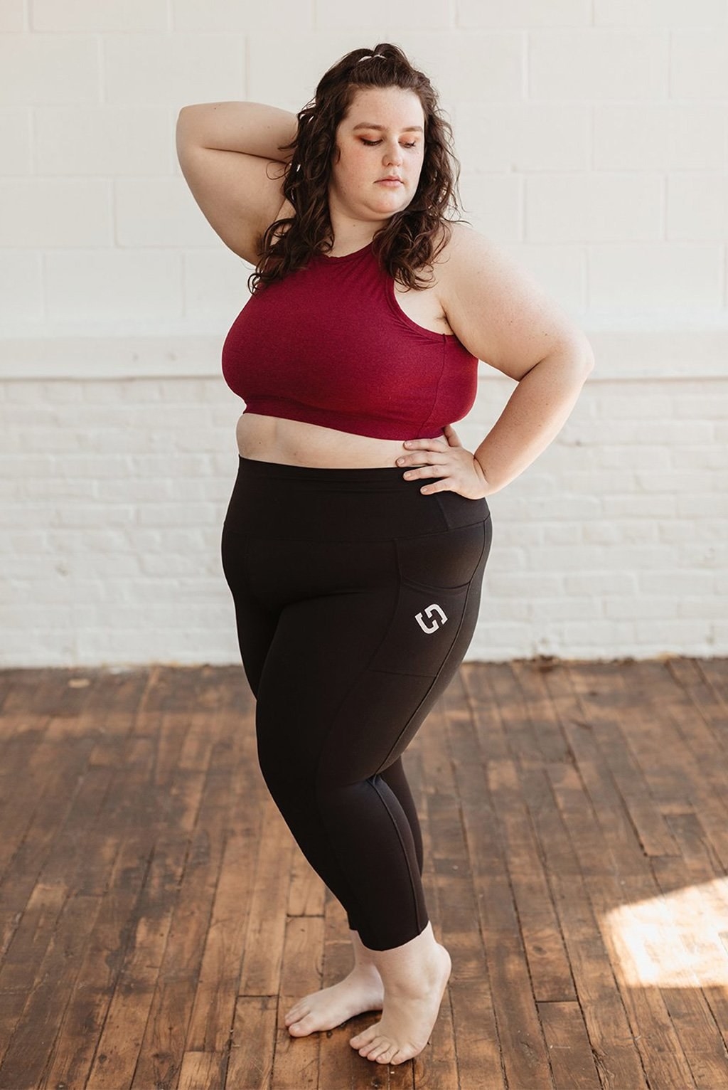 model wearing black leggings and a red sports bra
