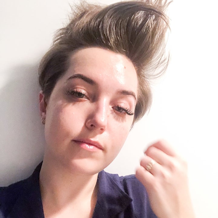 A person looking into the camera; their hair is lifted sky-high