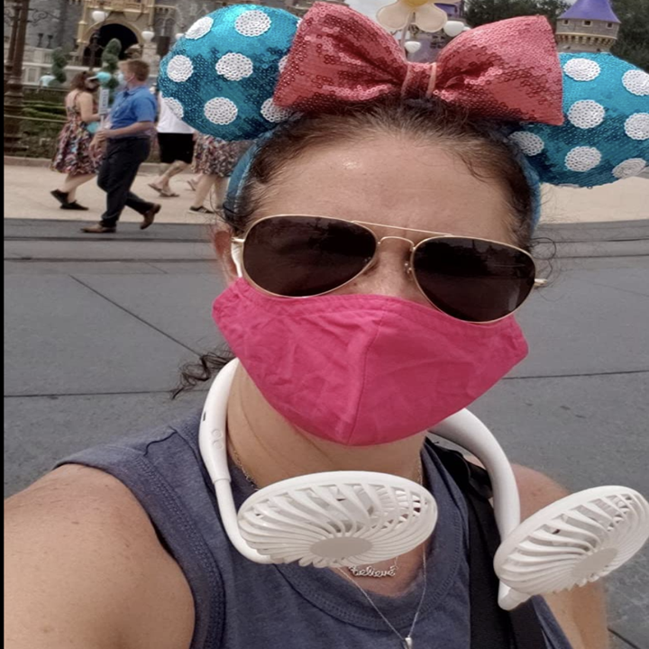 Reviewer with two white fans propped around their neck 