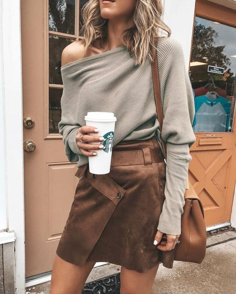 person wearing the off the shoulder top with a skirt holding a Starbucks cup