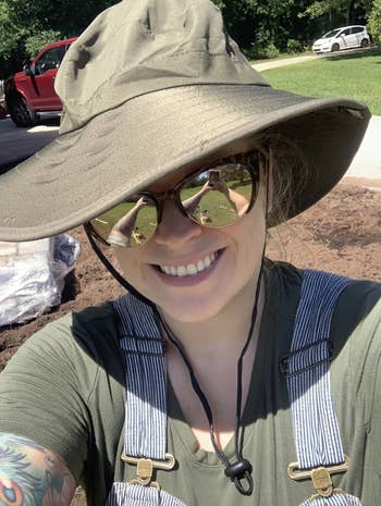 Reviewer in wide brimmed beige floppy hat with chin strap 