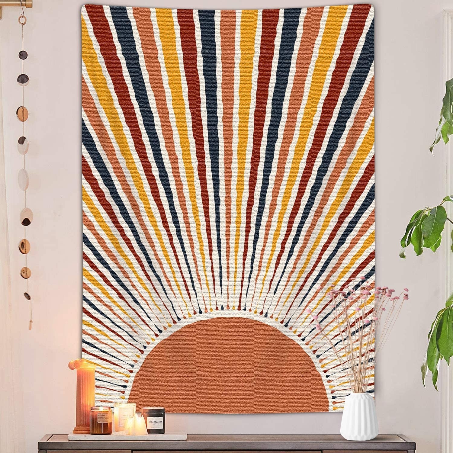 a tapestry hung on a wall with a sun and rays painted onto it