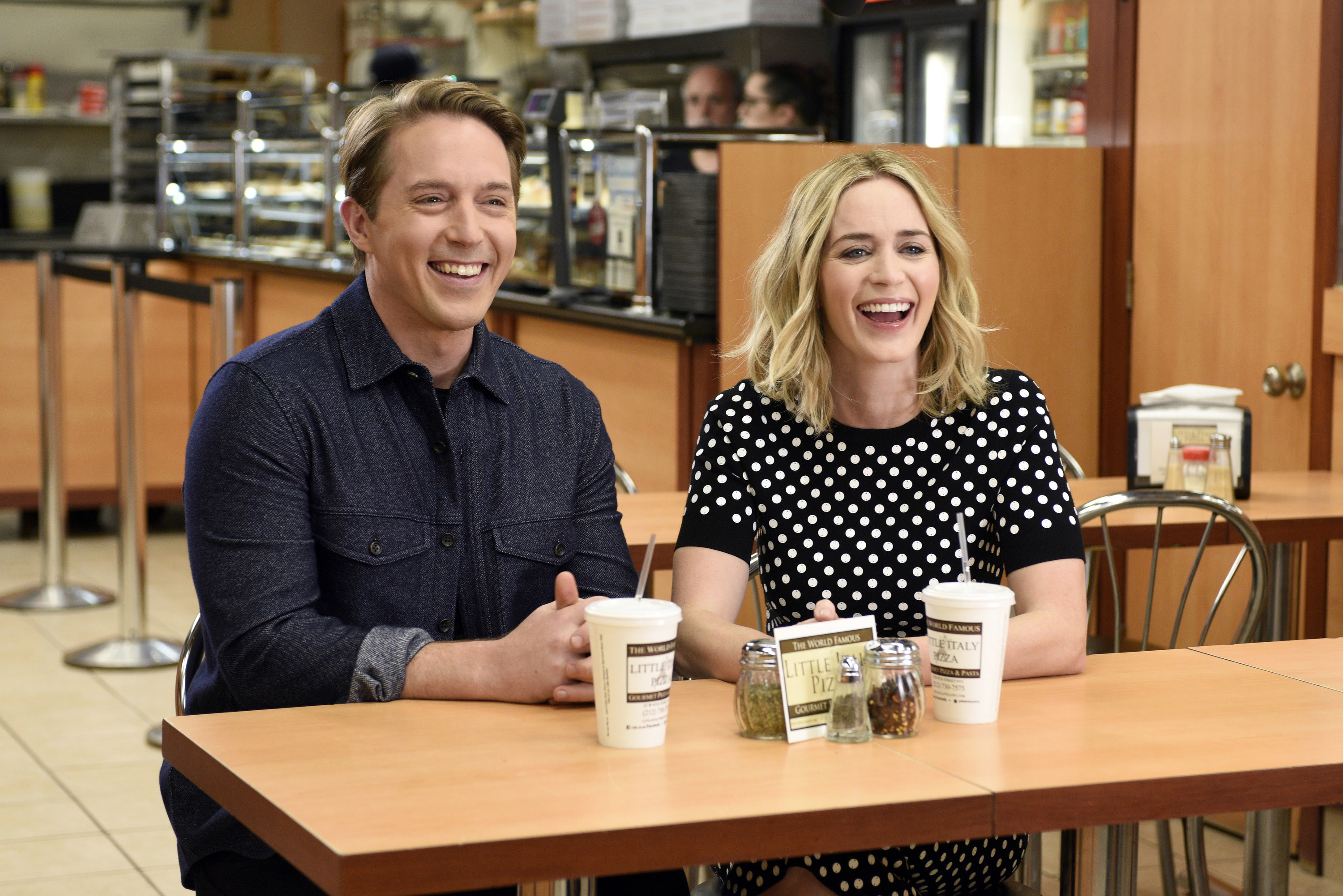 Emily laughs while wearing a black-and-white polka-dot top