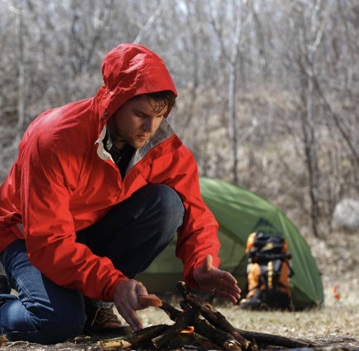 A person trying to start a camp fire