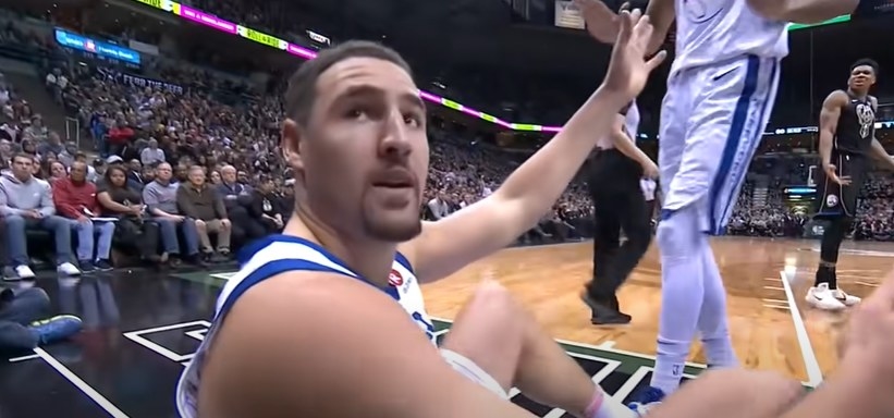 Klay Thompson looking back at crowd while on the ground