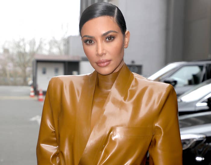 Kim looks serious while wearing a brown latex top