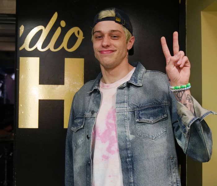 Pete holds up a peace sign while standing outside the studio