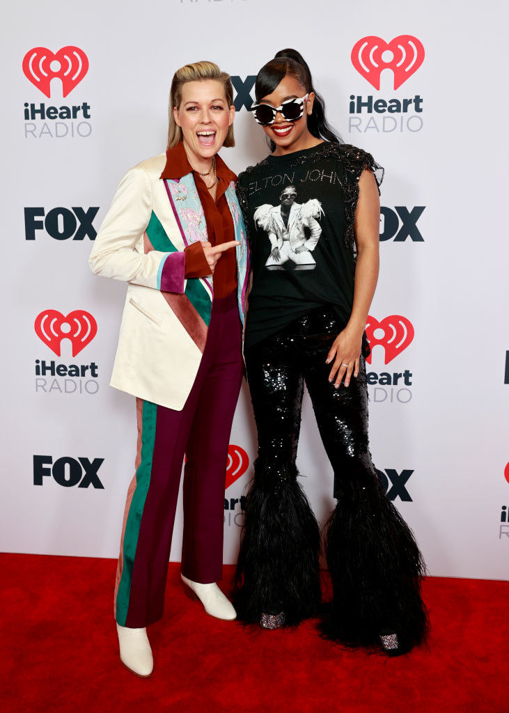 (L-R) Brandi Carlile wore a multicolored suit and H.E.R. wore an Elton John shirt and sequined bell bottom pants