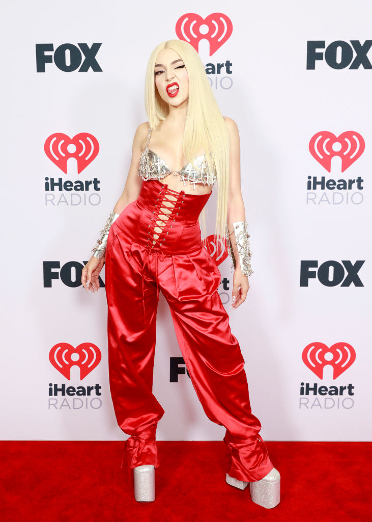 Ava Max attends the 2021 iHeartRadio Music Awards in a bra top, satin pants, and platform shoes