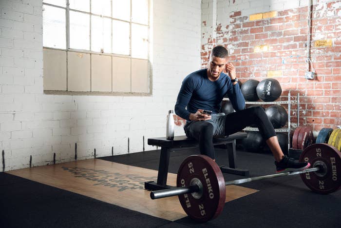 Man checking his phone at the gym