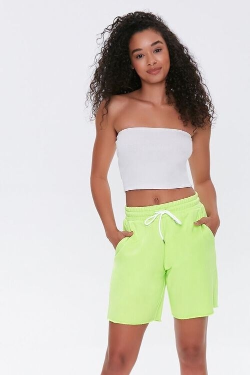 Model wearing neon yellow shorts with adjustable white laces