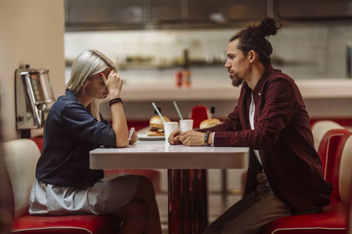 Photo of a guy and a girl looking upset at a diner 