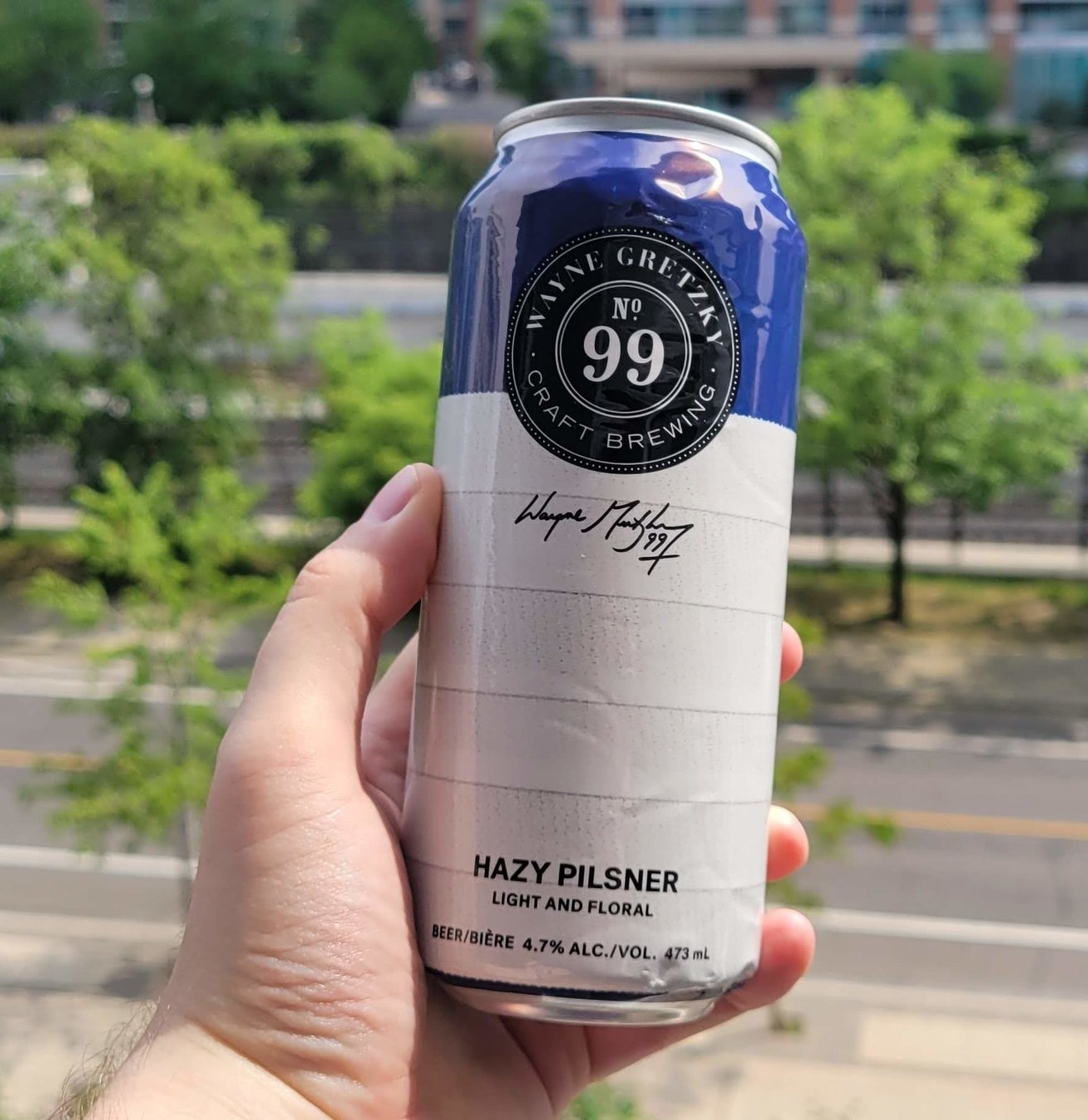 A can of Hazy Pilsner by Wayne Gretzky being held in a hand.